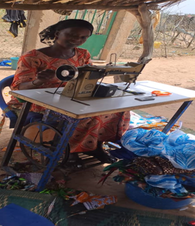 Mme Haby Oumar Saw avec la machine à coudre qu'elle a pu acheter grâce aux revenus supplémentaires